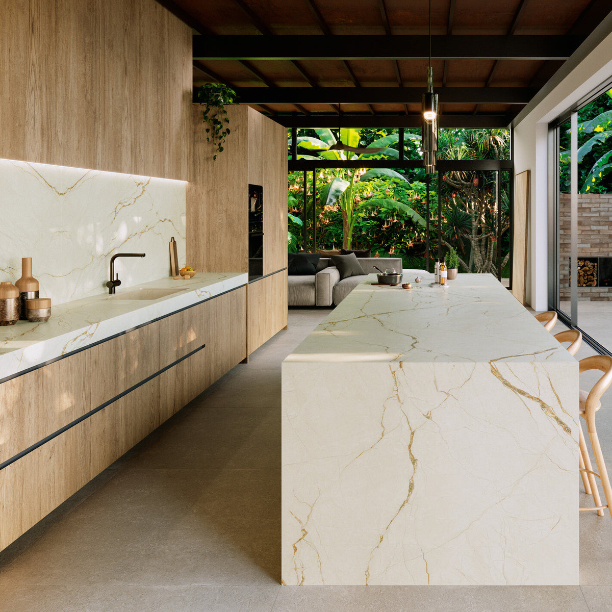 Grespania Canela Roma marble effect splashback, worktop and waterfall island in a kitchen overlooking a tropical garden