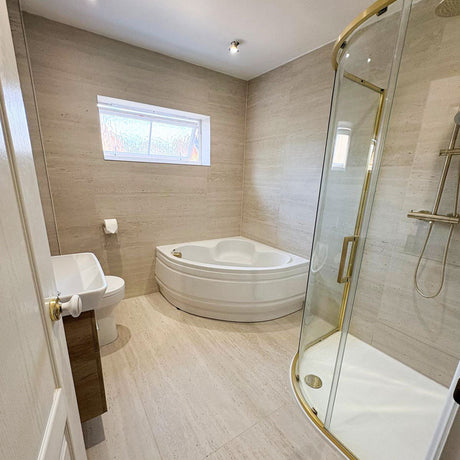 Main finished bathroom with a corner bath and brushed brass quadrant shower